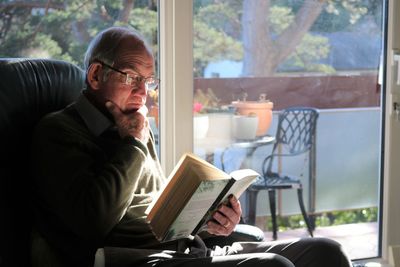 Elderly man reading book at home