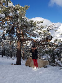 Man standing on snow covered tree against mountain