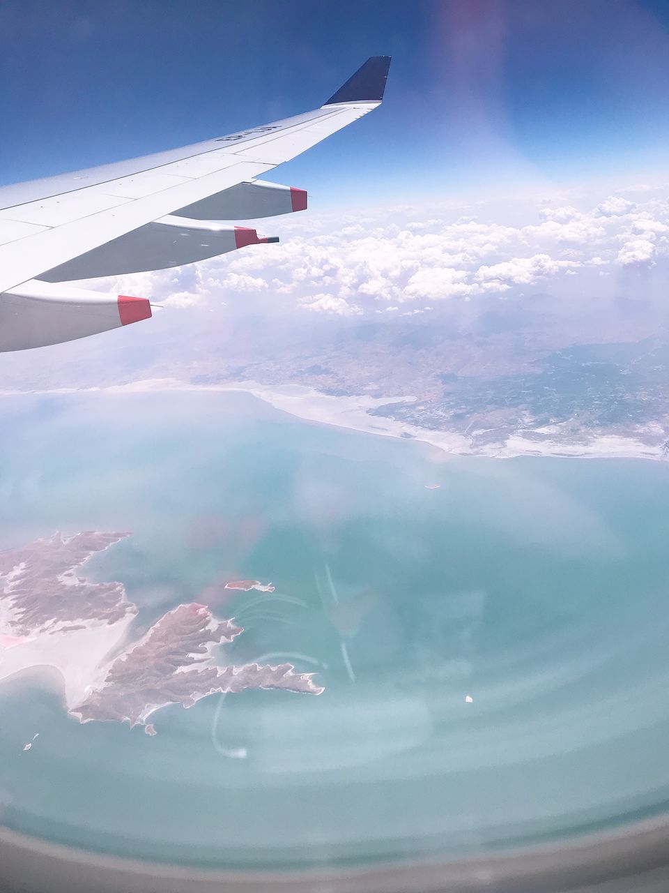 AERIAL VIEW OF AIRCRAFT WING OVER CLOUDS