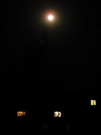 Low angle view of illuminated lights against sky at night