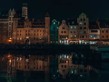 Reflection of buildings in lake at night