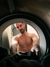 Man putting clothes in washing machine