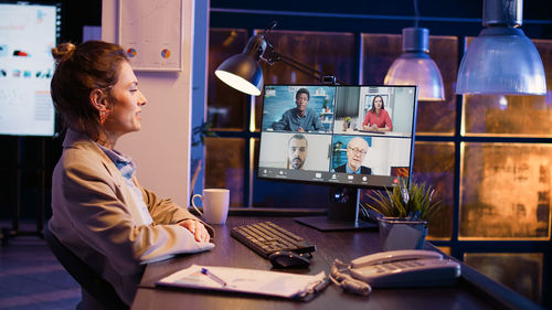 Side view of woman using laptop at table