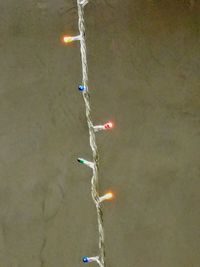 Illuminated lighting equipment on beach against sky