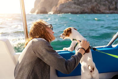 Side view of woman with dog in sea
