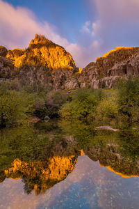 Scenic view of lake by mountain against sky