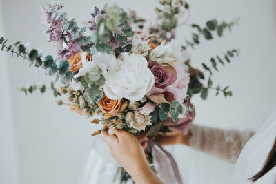 Midsection of woman holding bouquet of white rose