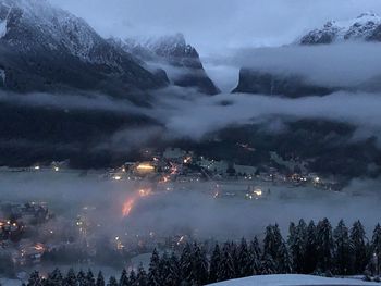 Scenic view of illuminated mountains against sky during winter