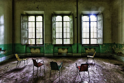 Empty chairs and table in abandoned building