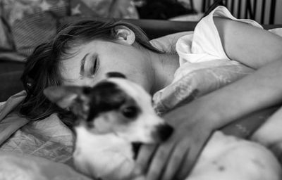 Midsection of woman with dog relaxing on sofa