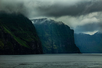Scenic view of sea and mountains against sky
