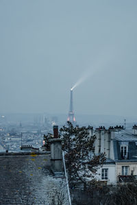 Illuminated light beam on top of eiffel tower against sky