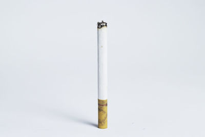 Close-up of cigarette smoking against white background