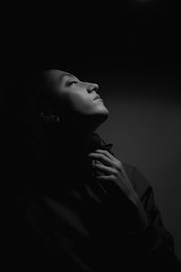 Close-up of young woman with eyes closed against wall