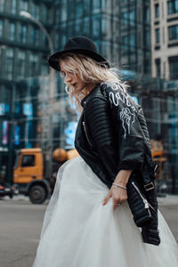 Woman with umbrella on street in city