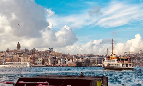 Boats in sea against buildings in city