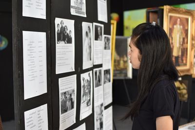 Woman reading paper on bulletin board