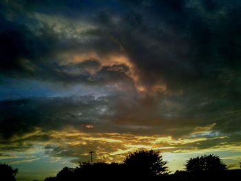 Silhouette of trees against dramatic sky