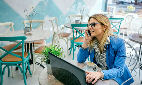 Young woman sitting on table at cafe
