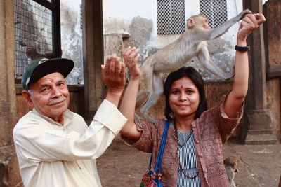 Portrait of happy man with daughter holding monkey