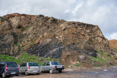 Cars on road by mountain against sky