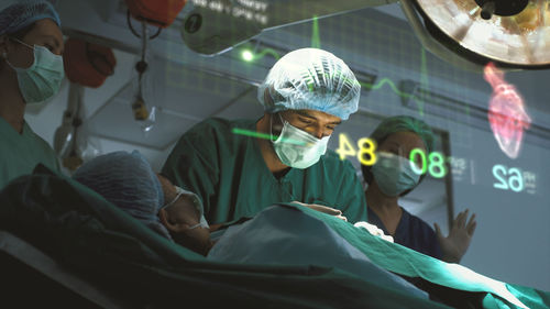 A surgeon diagnose a woman's heart problem via a holographic body scan before surgical procedure