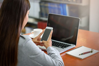 Midsection of woman using mobile phone