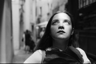 Close-up of woman looking up in city