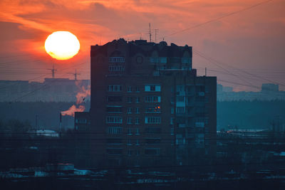 Silhouette buildings against sky during sunset