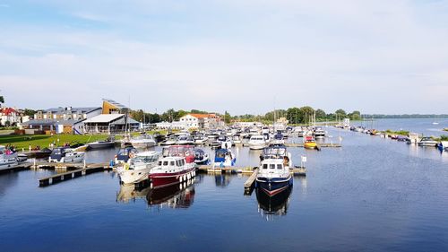 Boats moored in harbor against buildings in city