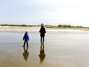 Full length rear view of woman standing on beach