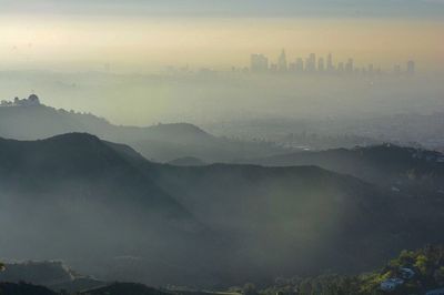 Aerial view of city against cloudy sky