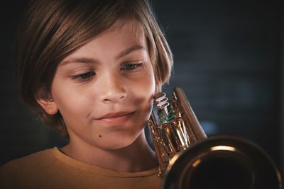 Close-up of boy holding brass instrument