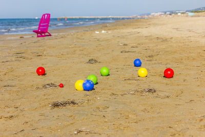 Multi colored toy on sand at beach against sky