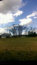 Scenic view of grassy field against cloudy sky