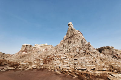 Low angle view of rock formations against sky