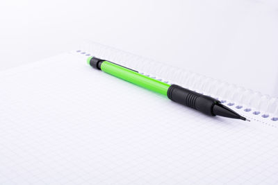 Close-up of pencil on spiral notebook