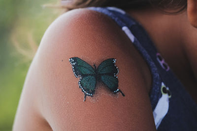 Close-up of girl shoulder with fake tattoo