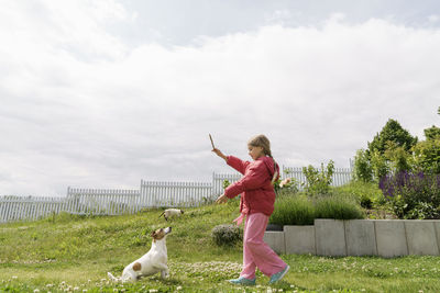 Girl playing with dog in garden