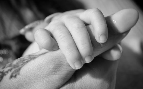 Cropped image of mother and child holding hands