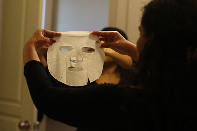 Woman using facial mask at home