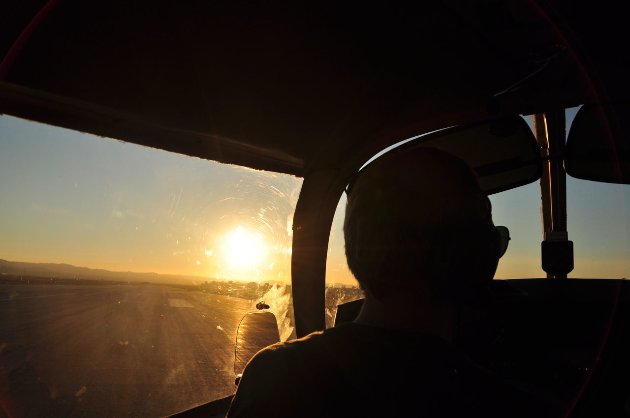 sun, sunset, sunlight, transportation, vehicle interior, sunbeam, sky, silhouette, lens flare, travel, car, mode of transport, window, glass - material, lifestyles, part of, personal perspective, leisure activity