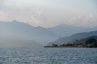 Scenic view of sea and mountains against sky