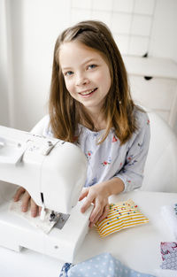 Portrait of a smiling girl sitting on table