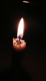 Close-up of burning candle in darkroom