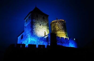 Close-up of illuminated building against clear blue sky