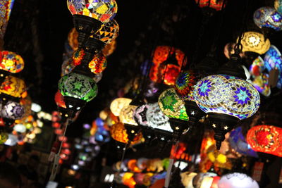 Close-up of illuminated lanterns hanging at market stall