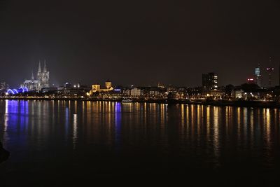 Illuminated city at waterfront at night