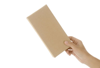 Low section of person holding paper against white background