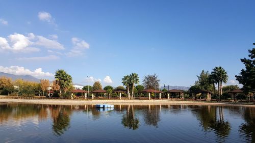 Swimming pool by lake against sky